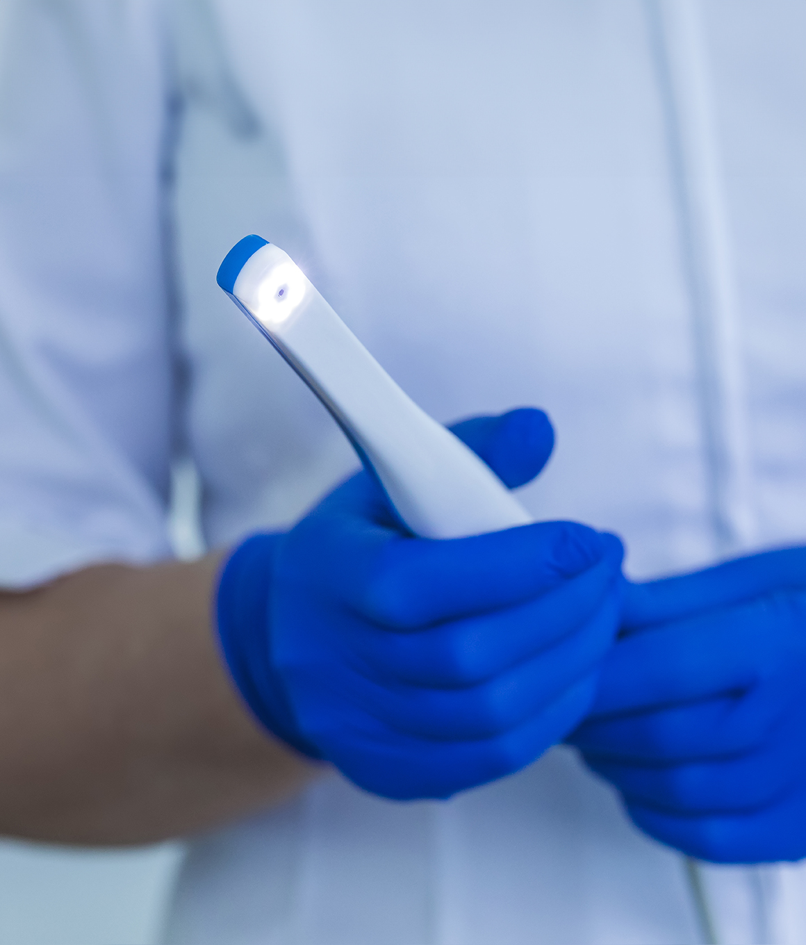 Dental team member holding a thin white intraoral camera