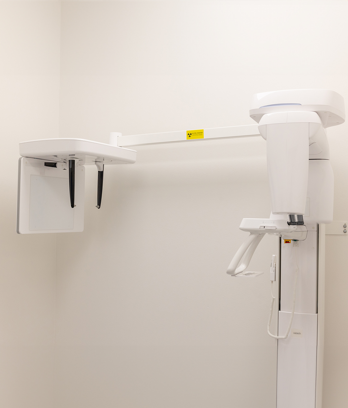 Panoramic x ray machine standing against white wall