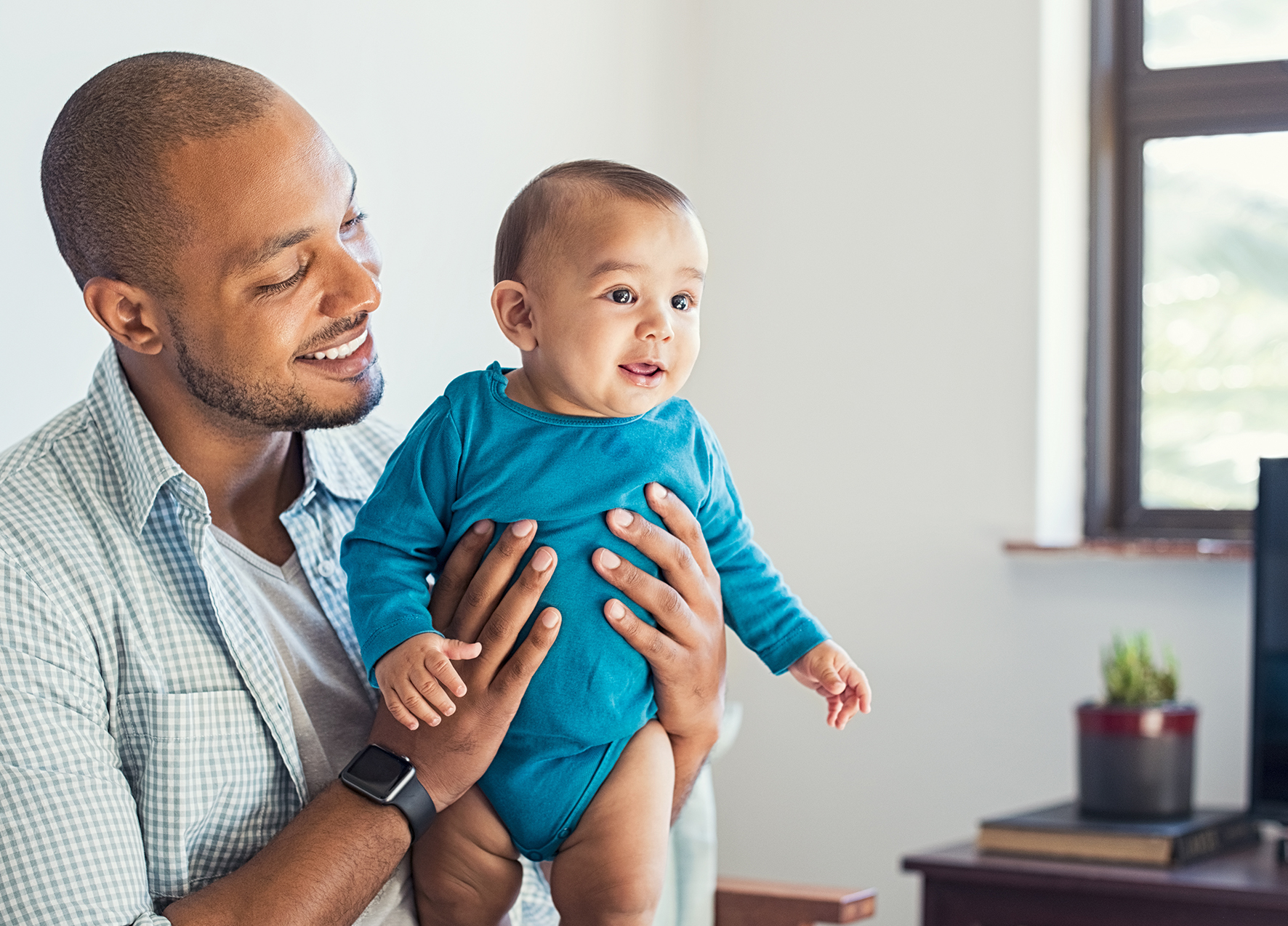 Man holding his baby after seeing dentist for infants in Murphy