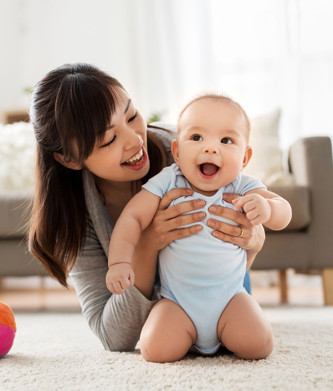 Woman laughing while holding her baby