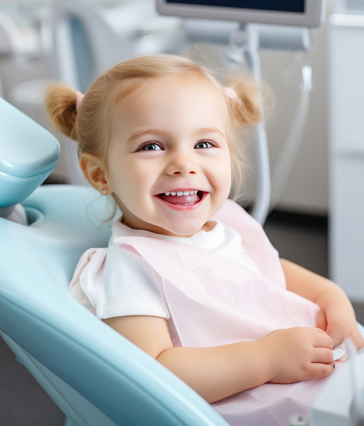 Young girl with pigtails smiling in dental chair