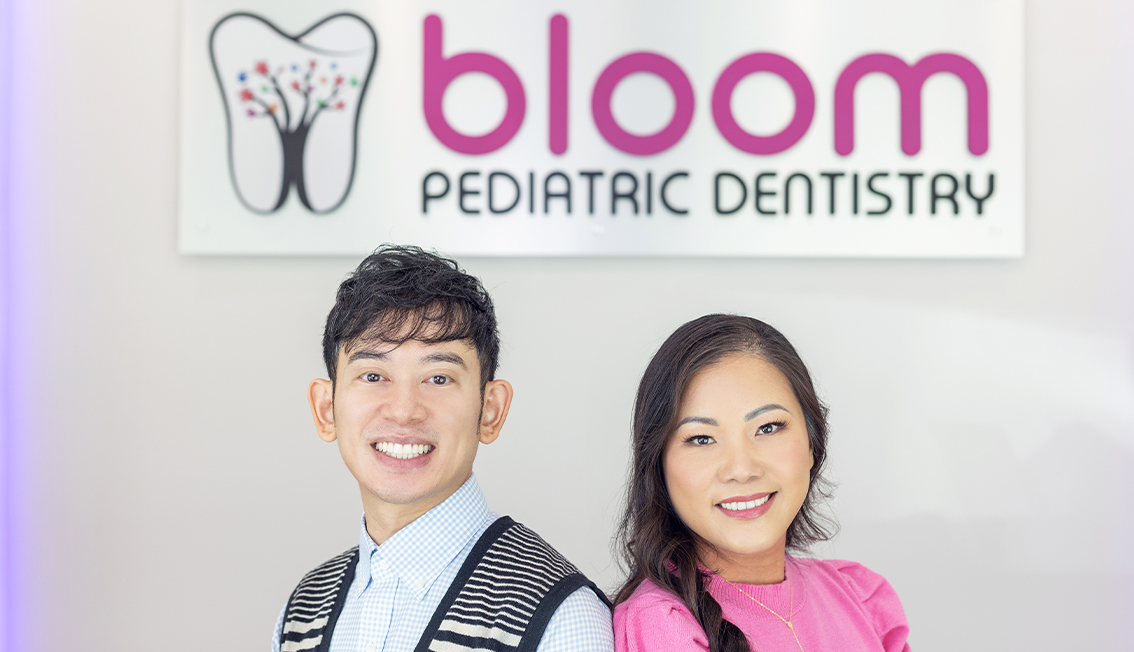 Murphy pediatric dentists Doctor Nelson Hui and Doctor Josephine Yip smiling in front of Bloom Pediatric Dentistry sign