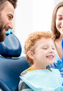 Child smiling in mirror after getting metal-free filling