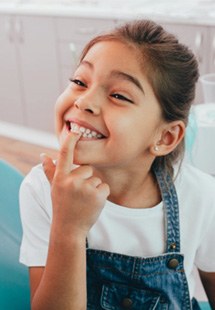 Smiling child pointing to their tooth