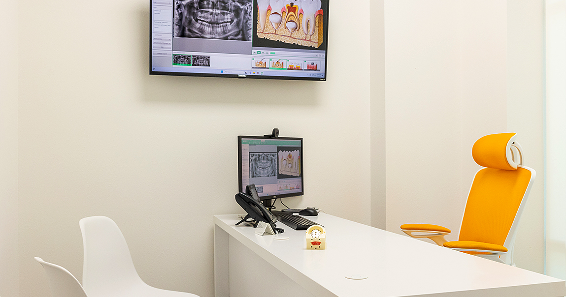 Computer on desk showing x rays and models of teeth