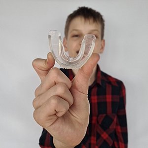 Child holding clear mouthguard