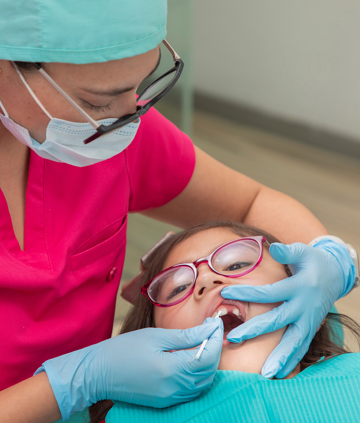 Child dental patient having fluoride applied to their teeth