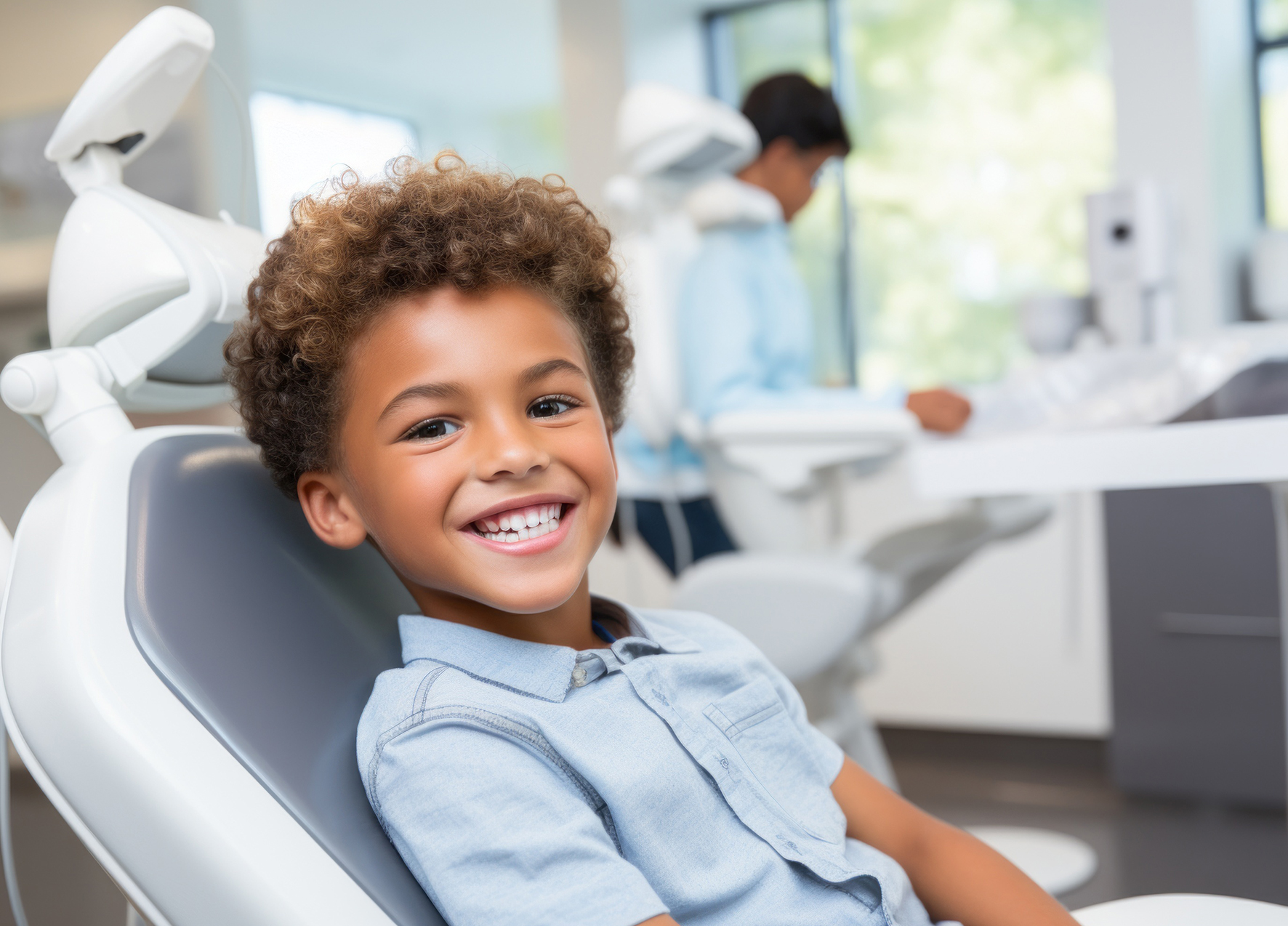 Young boy smiling in dental chair after receiving pulp therapy in Murphy