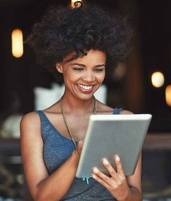 Woman looking at tablet for pediatric dentist reviews in Murphy