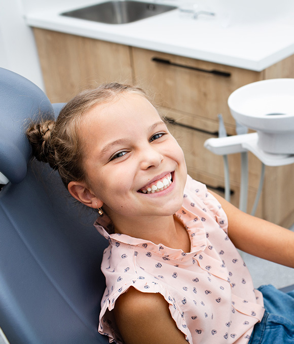 Young girl grinning in dental chair