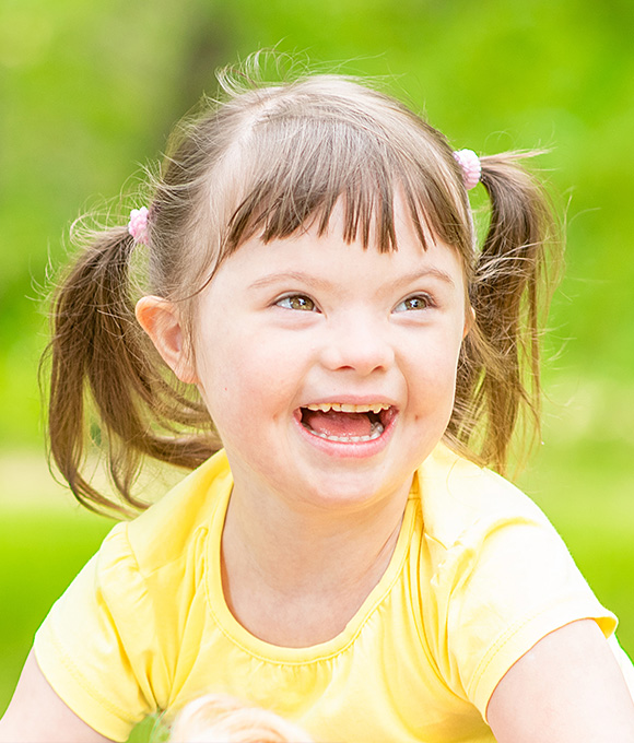 Girl with pigtails smiling outdoors