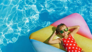 Little girl rocking a pair of shades and chilling on a pool floaty