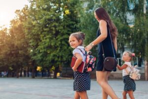 a parent walking her children to school