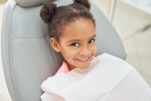 Happy, smiling young girl in dental treatment chair